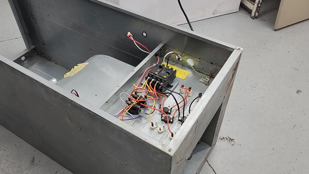 Open electric furnace cabinet showing circuit breakers, contactors and color-coded wiring